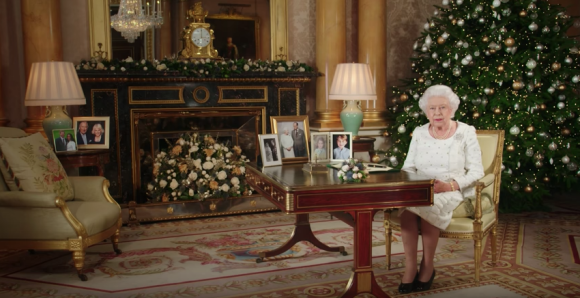 La reine Elizabeth II dans le salon 1844 au palais de Buckingham pour son allocution de Noël, le 25 décembre 2017. Sur le bureau à côté d'elle, des photos de George et Charlotte de Cambridge, de son mariage avec le prince Philip et de leurs noces de platine. Mais dans la pièce figurait aussi une photo des fiançailles du prince Harry et de Meghan Markle, qui s'apprête à entrer dans la famille.