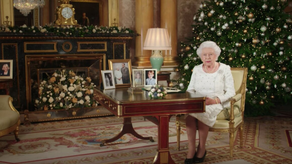Allocution de Noël de la reine Elizabeth II depuis le salon 1844 au palais de Buckingham, le 25 décembre 2017. Sur le bureau à côté d'elle, des photos de George et Charlotte de Cambridge, de son mariage avec le prince Philip et de leurs noces de platine. Mais dans la pièce figurait aussi une photo des fiançailles du prince Harry et de Meghan Markle, qui s'apprête à entrer dans la famille.
