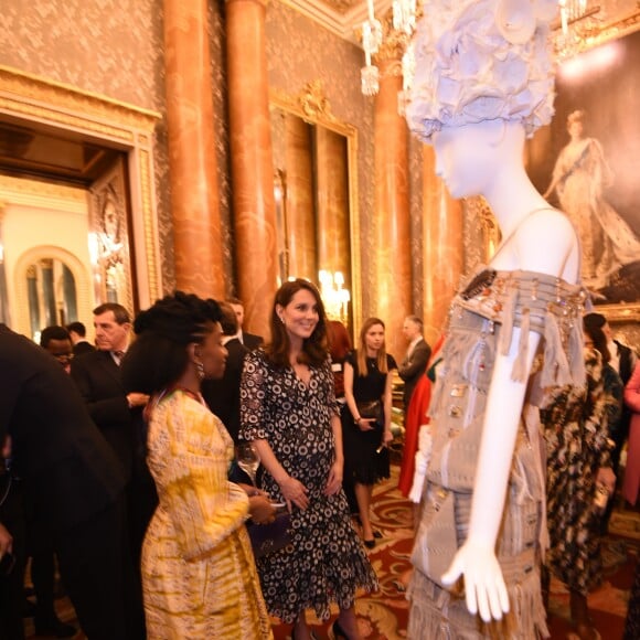 La duchesse Catherine de Cambridge, enceinte et en Erdem, découvre l'une des pièces exposées lors de la réception organisée pour célébrer le "Commonwealth Fashion Exchange" au Palais de Buckingham à Londres, le 19 février 2018.