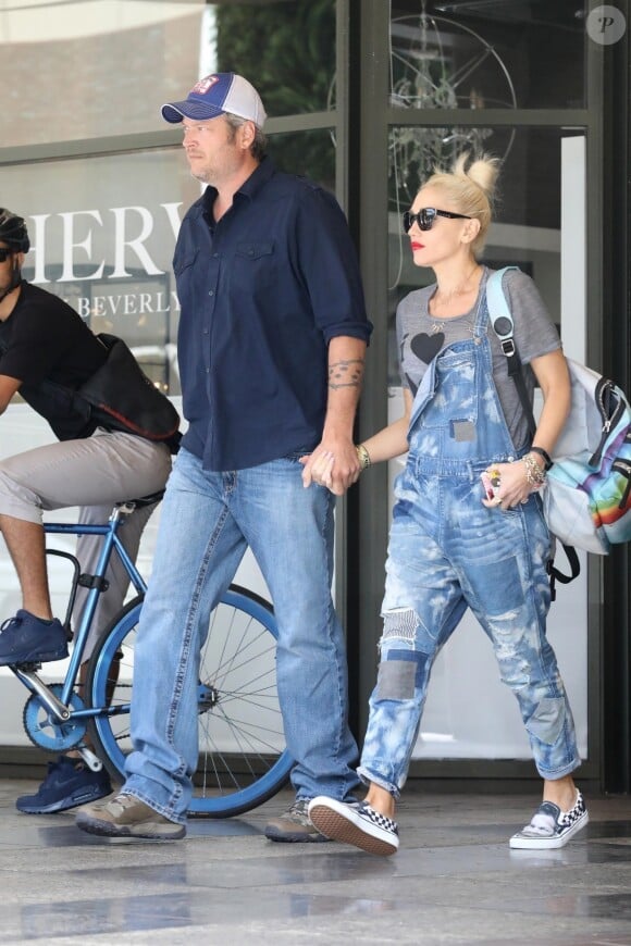 Exclusif - Gwen Stefani se balade main dans la main avec son compagnon Blake Shelton à Beverly Hills. Elle porte une salopette en jean et des baskets Vans avec la photo de Blake dessus! Le 20 septembre 2017
