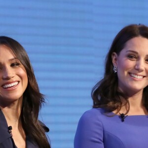 Meghan Markle et la duchesse Catherine. Kate Middleton, duchesse de Cambridge, enceinte de huit mois (en robe Seraphine), Meghan Markle (dans un ensemble Jason Wu), le prince William et le prince Harry étaient rassemblés pour la première fois en engagement public le 28 février 2018 pour le premier Forum annuel de la Fondation royale, au siège social d'Aviva à Londres, autour du thème "Changer les choses ensemble".