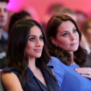 Meghan et Kate dans le public. Le prince Harry, Meghan Markle (dans un ensemble Jason Wu), la duchesse Catherine de Cambridge (robe de grossesse Seraphine), enceinte, et le prince William étaient rassemblés pour la première fois en engagement public le 28 février 2018 pour le premier Forum annuel de la Fondation royale, au siège social d'Aviva à Londres, autour du thème "Changer les choses ensemble".