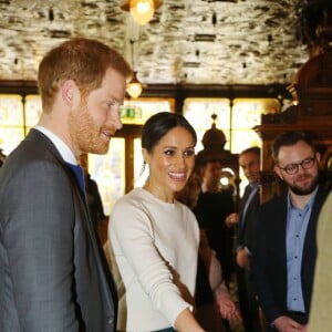 Le prince Harry et Meghan Markle visitent le Crown Liquor Saloon, un pub emblématique à la physionomie victorienne, le 23 mars 2018 lors de leur visite à Belfast. Ils y ont déjeuné (irish stew pour elle, saucisse pour lui) avant de poursuivre leur programme.