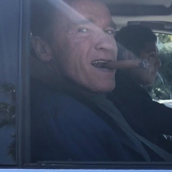 Exclusif - Arnold Schwarzenegger fume le cigare au volant de sa voiture à la sortie de l'hôtel Waldor Astoria à Beverly Hills, le 28 mars 2018