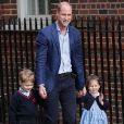  Le prince George, intimidé, et la princesse Charlotte de Cambridge, à l'aise, arrivent avec leur père le prince William à l'hôpital St Mary à Londres dans l'après-midi du 23 avril 2018 pour voir leur petit frère, auquel la duchesse Catherine a donné la vie à 11h01. 