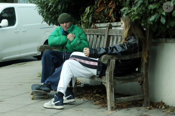 Exclusif - Rocco Ritchie s'arrête discuter sur un banc avec une jeune inconnue après avoir fait du skateboard dans les rues de Londres, le 31 octobre 2017.