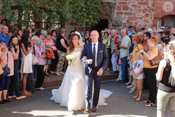 Thomas Hollande et Emilie Broussouloux, ici au bras de son père pour son arrivée à l'église, ont célébré leur mariage le 8 septembre 2018 dans le village de Meyssac, près de Brive en Corrèze, en présence notamment de François Hollande et Ségolène Royal, parents du marié.
