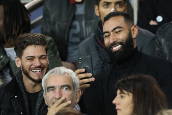 Rayane Bensetti, la Fouine (Laouni Mouhid) et Raymond Domenech dans les tribunes du parc des princes lors du match de football de ligue 1 opposant le Paris Saint-Germain (PSG) à l'Olympique Lyonnais (OL) à Paris, France, le 7 octobre 2018.