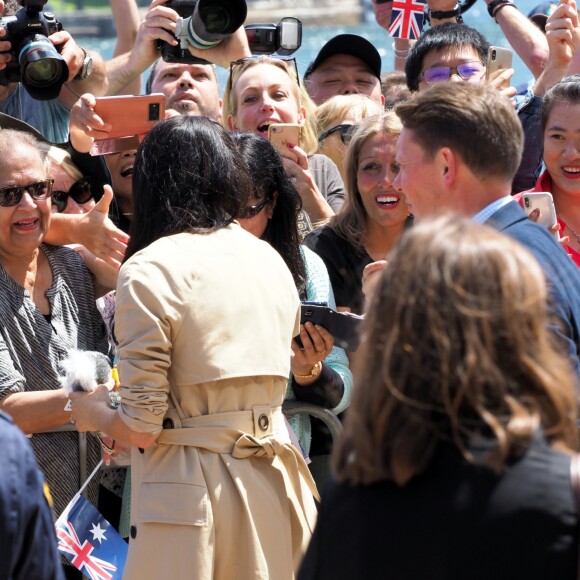 Le prince Harry, duc de Sussex et sa femme Meghan Markle, duchesse de Sussex (enceinte) discutent avec des habitants de Sydney au premier jour de leur première tournée officielle en Australie, le 16 octobre 2018
