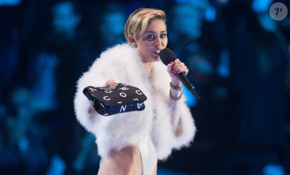 Miley Cyrus fume un joint lorsqu'elle va recevoir son prix aux MTV European Music Awards (EMA) 2013 au Ziggo Dome à Amsterdam le 10 novembre 2013.