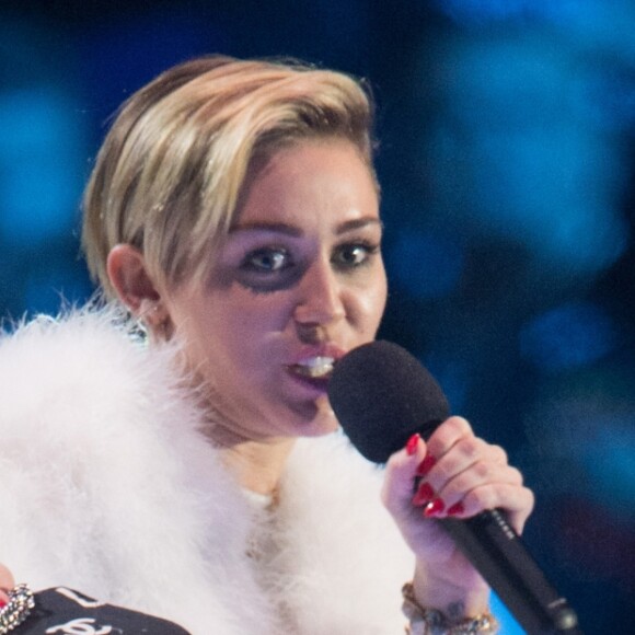 Miley Cyrus fume un joint lorsqu'elle va recevoir son prix aux MTV European Music Awards (EMA) 2013 au Ziggo Dome à Amsterdam le 10 novembre 2013.