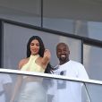 Kanye West et sa femme Kim Kardashian saluent la foule sur le balcon de leur nouvel appartement à Miami, le 4 janvier 2019.