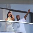 Kanye West et sa femme Kim Kardashian saluent la foule sur le balcon de leur nouvel appartement à Miami, le 4 janvier 2019.