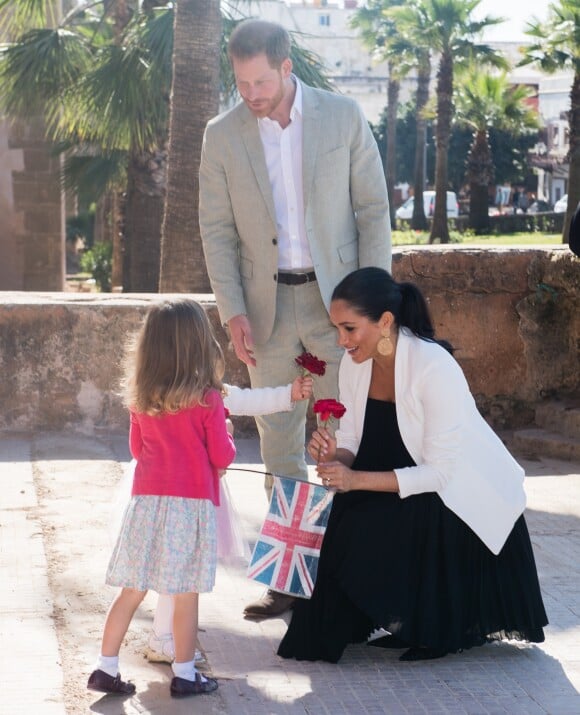 Le prince Harry et Meghan Markle, duchesse de Sussex, enceinte, accueillis par deux fillettes aux Jardins andalous à Rabat lors de leur voyage officiel au Maroc, le 25 février 2019. Harry s'est comiquement plaint que Meghan récolte toutes les fleurs et a été surpris lorsque l'une des deux petites filles, pour le consoler, lui en a tendu une !