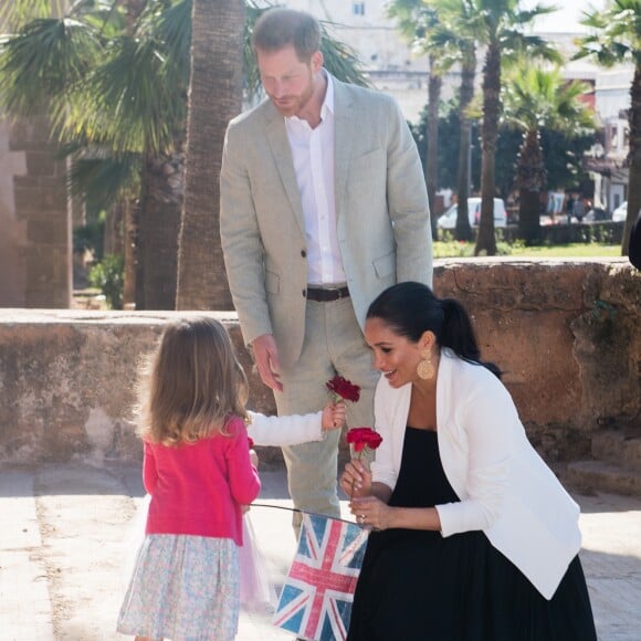 Le prince Harry et Meghan Markle, duchesse de Sussex, enceinte, accueillis par deux fillettes aux Jardins andalous à Rabat lors de leur voyage officiel au Maroc, le 25 février 2019. Harry s'est comiquement plaint que Meghan récolte toutes les fleurs et a été surpris lorsque l'une des deux petites filles, pour le consoler, lui en a tendu une !