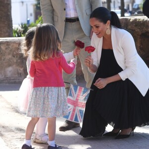 Le prince Harry et Meghan Markle, duchesse de Sussex, enceinte, accueillis par deux fillettes aux Jardins andalous à Rabat lors de leur voyage officiel au Maroc, le 25 février 2019. Harry s'est comiquement plaint que Meghan récolte toutes les fleurs et a été surpris lorsque l'une des deux petites filles, pour le consoler, lui en a tendu une !