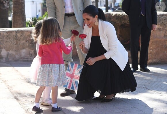 Le prince Harry et Meghan Markle, duchesse de Sussex, enceinte, accueillis par deux fillettes aux Jardins andalous à Rabat lors de leur voyage officiel au Maroc, le 25 février 2019. Harry s'est comiquement plaint que Meghan récolte toutes les fleurs et a été surpris lorsque l'une des deux petites filles, pour le consoler, lui en a tendu une !