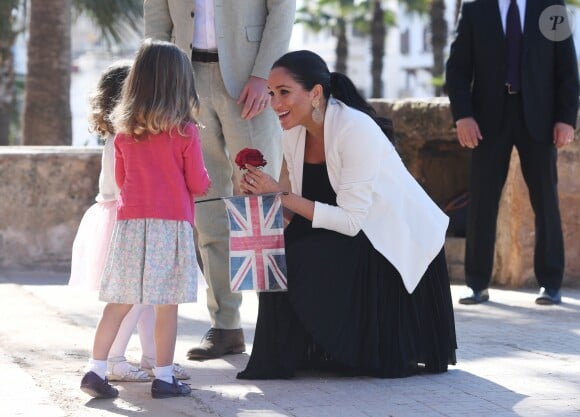 Le prince Harry et Meghan Markle, duchesse de Sussex, enceinte, accueillis par deux fillettes aux Jardins andalous à Rabat lors de leur voyage officiel au Maroc, le 25 février 2019. Harry s'est comiquement plaint que Meghan récolte toutes les fleurs et a été surpris lorsque l'une des deux petites filles, pour le consoler, lui en a tendu une !