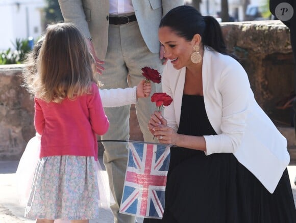 Le prince Harry et Meghan Markle, duchesse de Sussex, enceinte, accueillis par deux fillettes aux Jardins andalous à Rabat lors de leur voyage officiel au Maroc, le 25 février 2019. Harry s'est comiquement plaint que Meghan récolte toutes les fleurs et a été surpris lorsque l'une des deux petites filles, pour le consoler, lui en a tendu une !