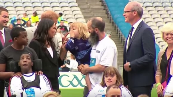 Le prince Harry met comiquement en garde un petit garçon de 3 ans qui n'arrête pas de toucher les cheveux de Meghan Markle, en juillet 2018 en Irlande.