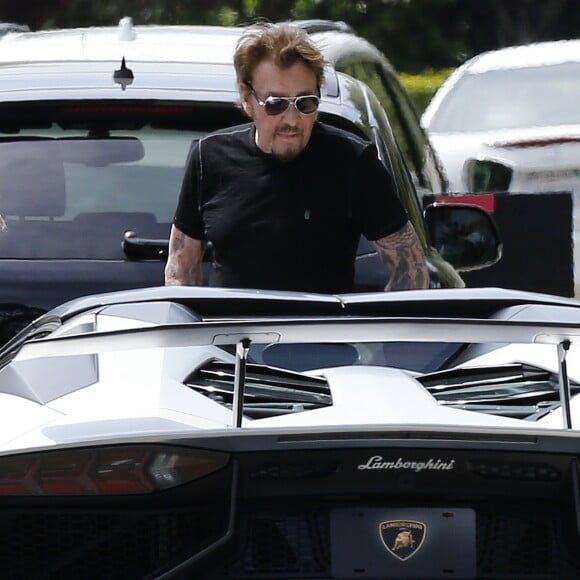 Une vendeuse de voiture de luxe vient faire découvrir une Lamborghini Aventador à Johnny Hallyday chez lui dans sa maison de Los Angeles, Californie, Etats-Unis, le 9 avril 2017.