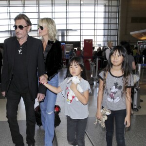 Johnny Hallyday avec sa femme Laeticia et ses enfants Jade et Joy en partance pour Paris arrivent à l'aéroport Lax de Los Angeles le 25 juin 2016.