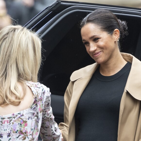 Meghan Markle, en trench-coat Oscar de la Renta, robe Hatch, chaussures Gianvito Rossi et sac Victoria Beckham, en visite chez Smartworks, à Londres le 10 janvier 2019.