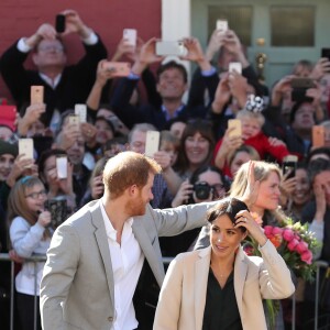 Le prince Harry et Meghan Markle, en jupe en cuir Hugo Boss, blouse & Other Stories, manteau Armani et sac Gabriela Hearst, à Brighton dans le Sussex le 3 octobre 2018.