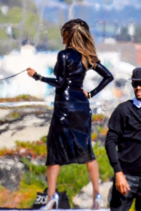 Exclusif  - Jennifer Aniston lors d'une une séance photo très sexy avec un Dobermann sur une plage de Malibu, Los Angeles, Californie, Etats-Unis, le 27 mars 2019. Jennifer porte une robe noire moulante, offrant un décolleté plongeant. Photoshoot pour le Harper's Bazaar.