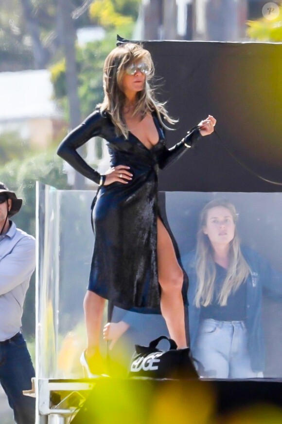 Exclusif  - Jennifer Aniston lors d'une une séance photo très sexy avec un Dobermann sur une plage de Malibu, Los Angeles, Californie, Etats-Unis, le 27 mars 2019. Jennifer porte une robe noire moulante, offrant un décolleté plongeant.