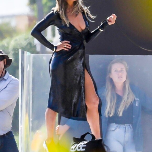 Exclusif  - Jennifer Aniston lors d'une une séance photo très sexy avec un Dobermann sur une plage de Malibu, Los Angeles, Californie, Etats-Unis, le 27 mars 2019. Jennifer porte une robe noire moulante, offrant un décolleté plongeant.