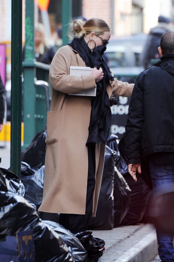 Exclusif - Adele se cache des photographes à la sortie d'un immeuble à New York, le 2 avril 2019.