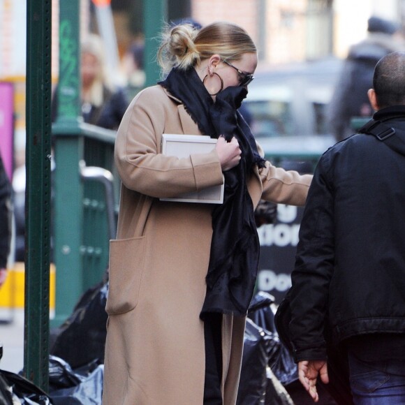 Exclusif - Adele se cache des photographes à la sortie d'un immeuble à New York, le 2 avril 2019.