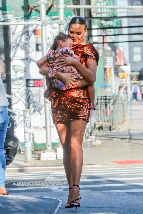 Chrissy Teigen se promène avec sa fille Luna dans les bras à New York, le 20 mai 2019.
