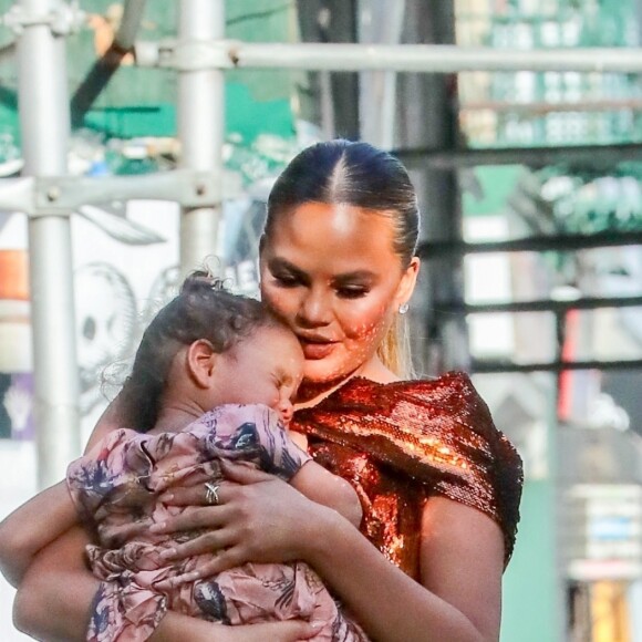 Chrissy Teigen se promène avec sa fille Luna dans les bras à New York, le 20 mai 2019.