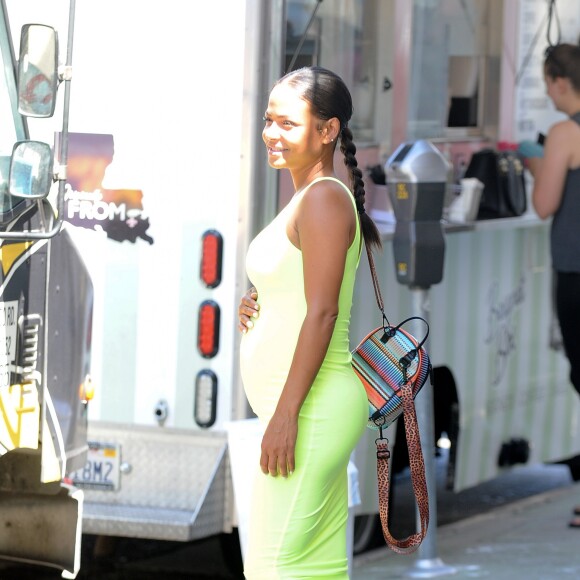 Christina Milian enceinte porte une robe vert fluo très moulante et pause pour les ohitigraphes devant son Beignet Box truck à Studio City, Los Angeles, le 29 août 2019