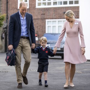Le prince George de Cambridge, ici accueilli par la directrice Helen Haslem, a fait sa première rentrée des classes à l'école Thomas's Battersea le 7 septembre 2017 à Londres, escorté par son père le prince William. Sa mère Kate Middleton n'était pas en état de l'accompagner, souffrant des symptômes du début de sa troisième grossesse révélée quelques jours plus tôt.
