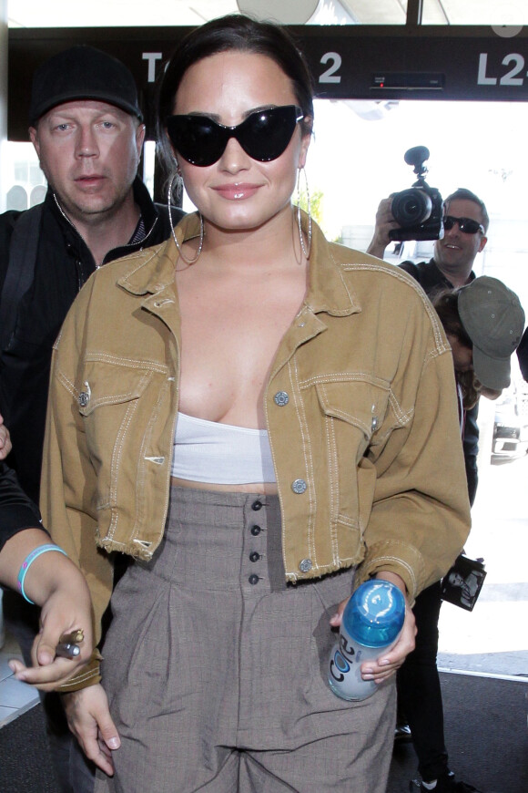 Demi Lovato arrive à l'aéroport de LAX à Los Angeles pour prendre l'avion. Demi porte un top bandeau sans soutien gorge! Le 22 janvier 2018
