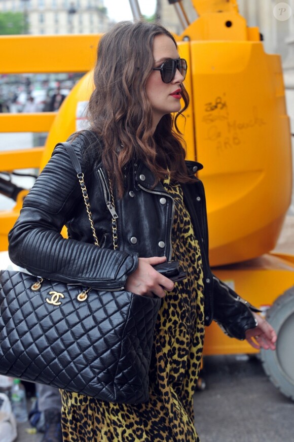 Keira Knightley, enceinte et son mari James Righton sont à Paris à l'occasion du défilé croisière Chanel. Keira porte une robe jaune imprimée léopard, un perfecto, des bottes et un sac à main Chanel en cuirs. Départ de Paris pour Londres, le 3 mai 2019.