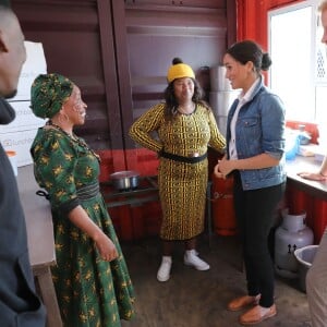 Le prince Harry, duc de Sussex, et Meghan Markle, duchesse de Sussex rencontrent des membres de l'association "Lunchbox Fund" qui fournit près de 30 000 repas chaque jour dans les zones rurales, lors de leur 2ème jour en Afrique du Sud, le 24 septembre 2019. Le couple est allé rendre visite aux membres de "Waves for Change", un organisme de bienfaisance qui travaille avec les surfeurs locaux sur la plage Monwabisi.  The Duke and Duchess of Sussex in the compound kitchen, where charity The Lunchbox Fund, provides nearly 30,000 nutritious meals every day to programmes in townships and rural areas, during a visit to Waves for Change at Monwabisi Beach in Cape Town, on day two of the royal tour of Africa.24/09/2019 - Le Cap