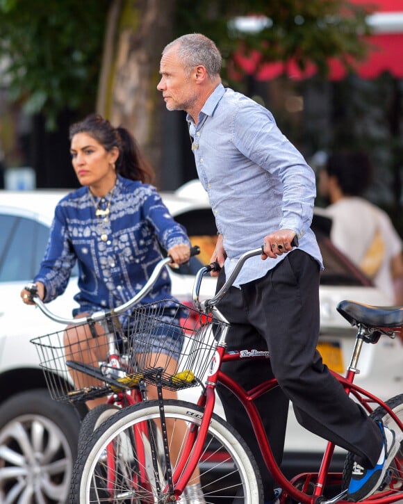 Exclusif - Le musicien Flea et sa compagne Melody Eshani se baladent en vélo dans les rues de New York, le 5 aout 2019.