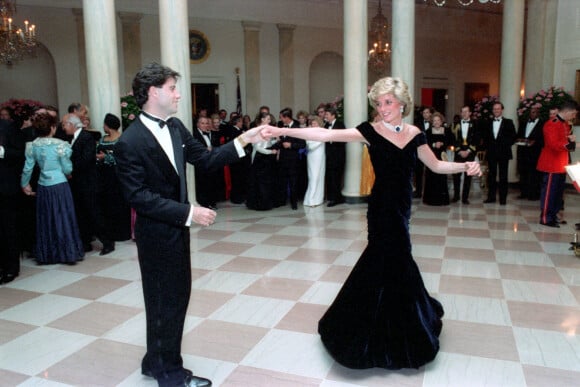 Lady Diana (dans sa robe en velours Victor Edelstein) et John Travolta lors du dîner officiel organisé à la Maison-Blanche par le président américain Ronald Reagan le 9 novembre 1985.
 