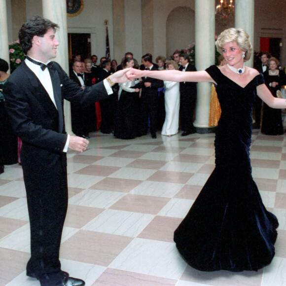 Lady Diana (dans sa robe en velours Victor Edelstein) et John Travolta lors du dîner officiel organisé à la Maison-Blanche par le président américain Ronald Reagan le 9 novembre 1985.
 