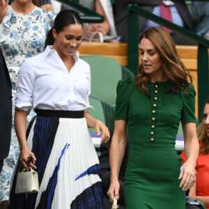 Meghan Markle (en jupe Hugo Boss), avec Kate Middleton et Pippa Middleton dans les tribunes lors de la finale femme de Wimbledon à Londres, le 13 juillet 2019.