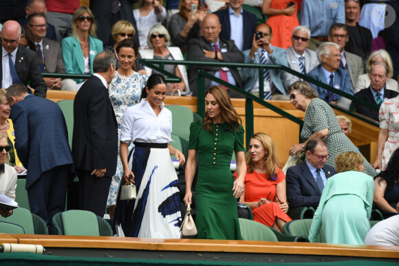 Meghan Markle (en jupe Hugo Boss), avec Kate Middleton et Pippa Middleton dans les tribunes lors de la finale femme de Wimbledon à Londres, le 13 juillet 2019.