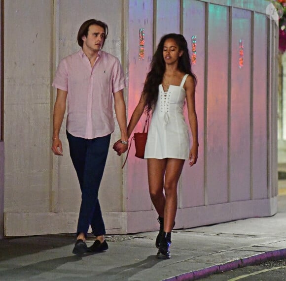 Exclusif - Prix spécial - No web No blog - Malia Obama et son compagnon Rory Farquharson ont été aperçus main dans la main dans les rues de Londres. Le couple est allé dîner au restaurant C London avant de faire une balade digestive. Ils se sont arrêtés devant la vitrine Breitling avant de monter dans un taxi, le 29 juillet 2018.  Exclusive - Germany call for price - Malia Obama and her boyfriend Rory Farquahson are spotted on stroll through the streets of Mayfair on Thursday evening . The couple had just finished a meal at the popular C restaurant in Central London. Malia & Rory had a cigarette as they made their way to catch a taxi . The couple can be seen taking a look into the Breitling watch store on Bond street . As they waited to catch a taxi . Malia wore a lovely white summery dress and Doctor Martens ankle boots for the date . And Rory a salmon pink shirt and navy blue trousers on a very warm evening in the Capital . Malia is wearing a gold band on her ring finger .29/07/2018 - Londres
