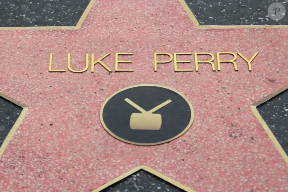 Luke Perry recevra son étoile sur le Walk Of Fame à Hollywood à titre posthume. L'acteur a eu une carrière bien remplie mais qui n'a encore jamais été honorée à travers une étoile sur le célèbre Walk of Fame. Il faudra malheureusement attendre au moins cinq ans avant que Luke Perry ne soit immortalisé sur le célèbre boulevard. D'après la chambre de commerce d'Hollywood, le processus est un peu plus compliqué compte tenu de la brutale disparition de Luke Perry.. Dans le cas d'une célébrité décédée, c'est la famille du défunt qui doit donner son accord, sachant qu'un seul candidat décédé est approuvé chaque année. Luke est décédé le 4 mars, ce qui signifie que le 4 mars 2024 est le plus tôt possible.. Le 11 mars 2019