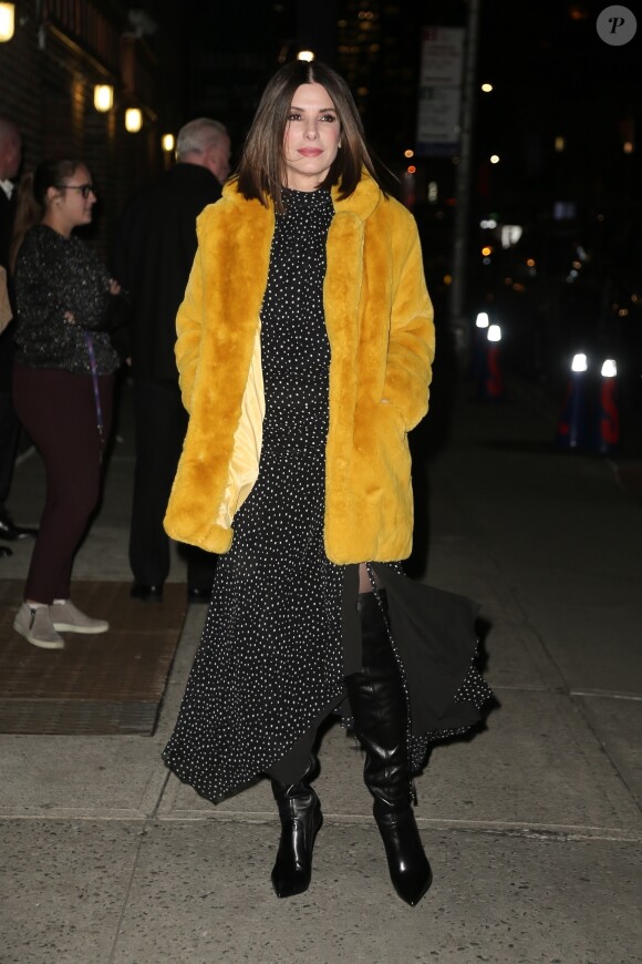 Sandra Bullock porte un manteau de fourrure jaune à son arrivée à l'émission The Late Show avec Stephen Colbert pour la promotion de son film Bird Box à New York, le 17 décembre 2018