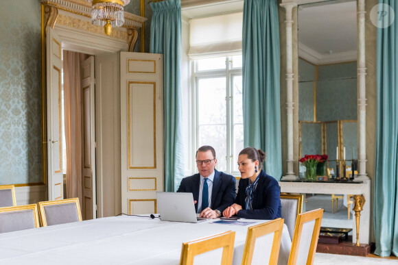La princesse Victoria de Suède et le prince Daniel le 3 avril 2020 lors d'une visioconférence avec les employés de la société de technologie médicale Getinge, depuis la salle à manger bleue du palais Haga, leur résidence à Solna, au nord de Stockholm.