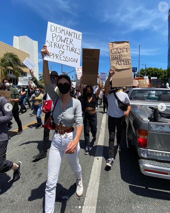 Emily Ratajkowski manifeste avec le mouvement Black Lives Matter contre les violences policières suite à la mort de George Floyd. Elle porte un carton sur lequel est inscrit : "Démantelez les structures de pouvoir de l'oppression". Los Angeles, le 30 mai 2020.